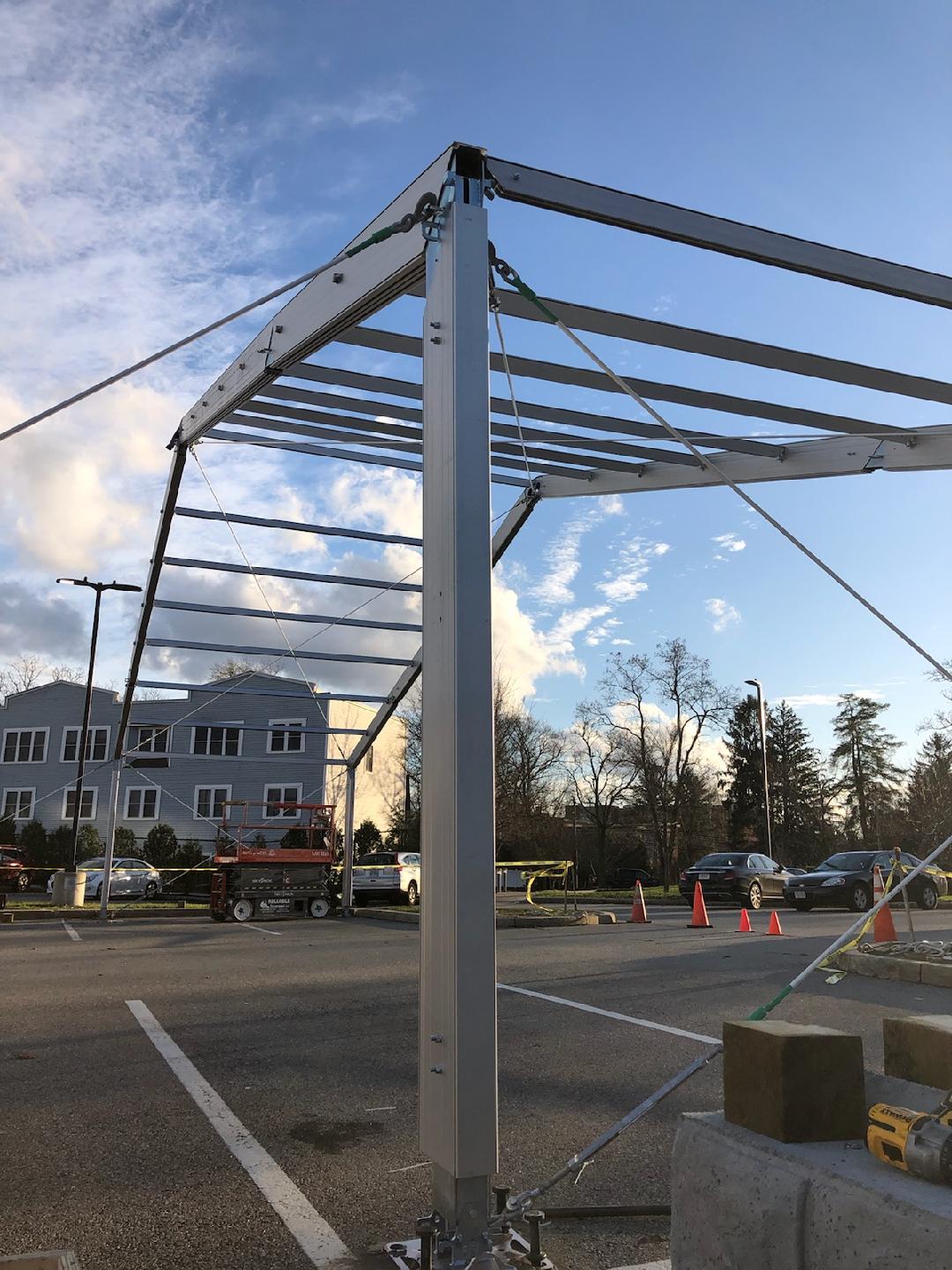 Temporary storage tent structure during setup showing aluminum frame and fabric for warehouse application
