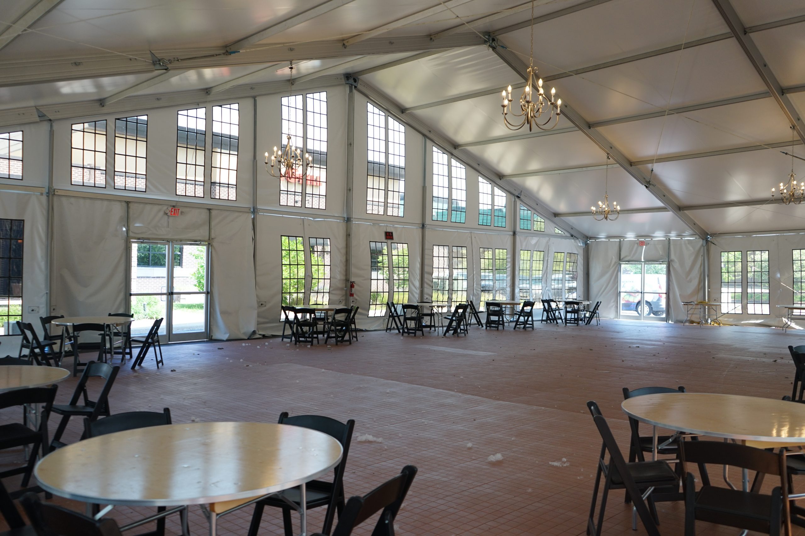 Base Camp Dining Hall — Interior with Seating Interior of base camp dining hall tent with round tables, chairs, chandeliers, and floor-to-ceiling windows