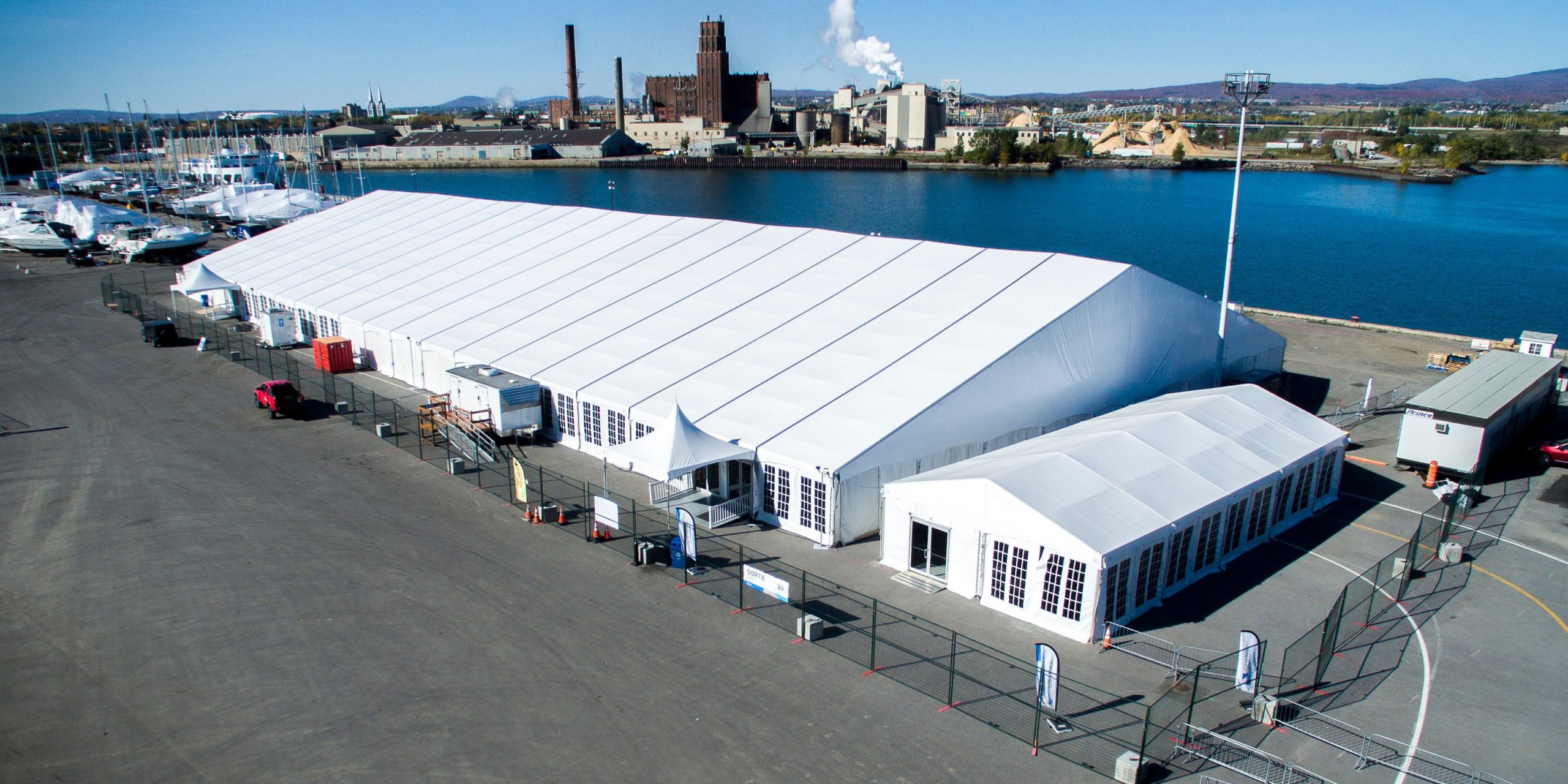 Aerial view of massive clearspan tent complex at a waterfront venue with multiple connected structures and HVAC for large-scale events